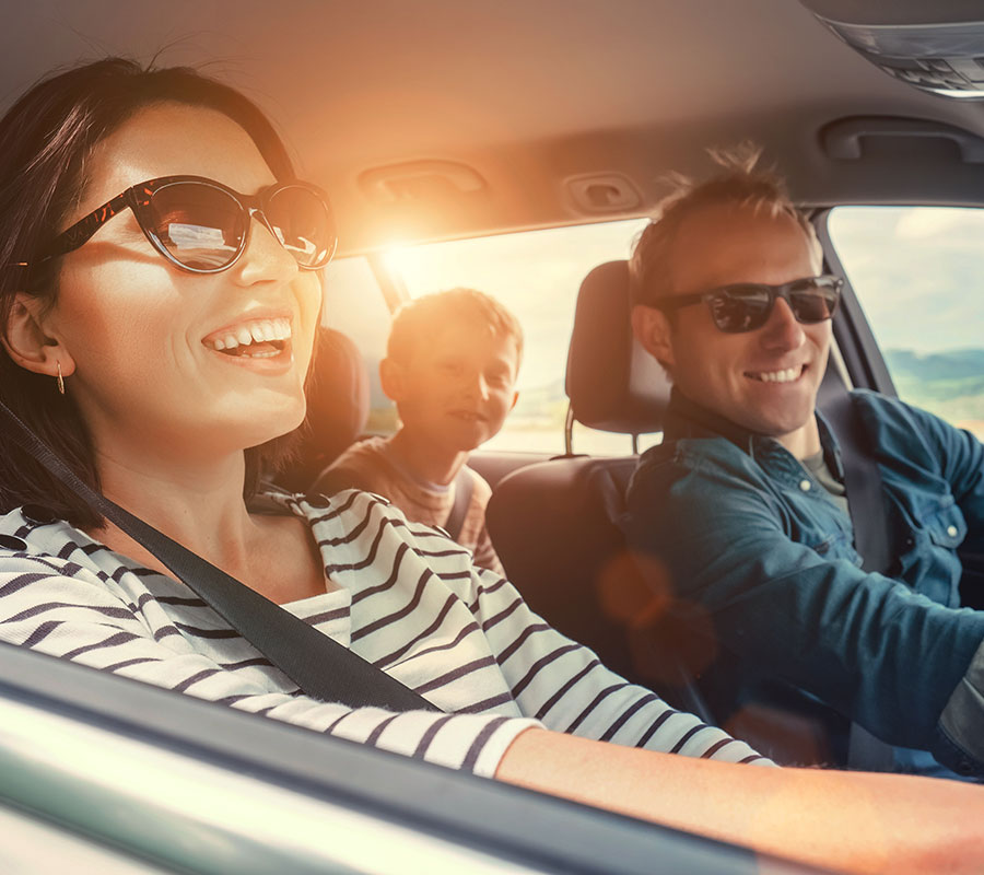 Family driving in car smiling because they took out car insurance with J. L. Bailey Insurance Brokers based in Keighley, West Yorkshire.